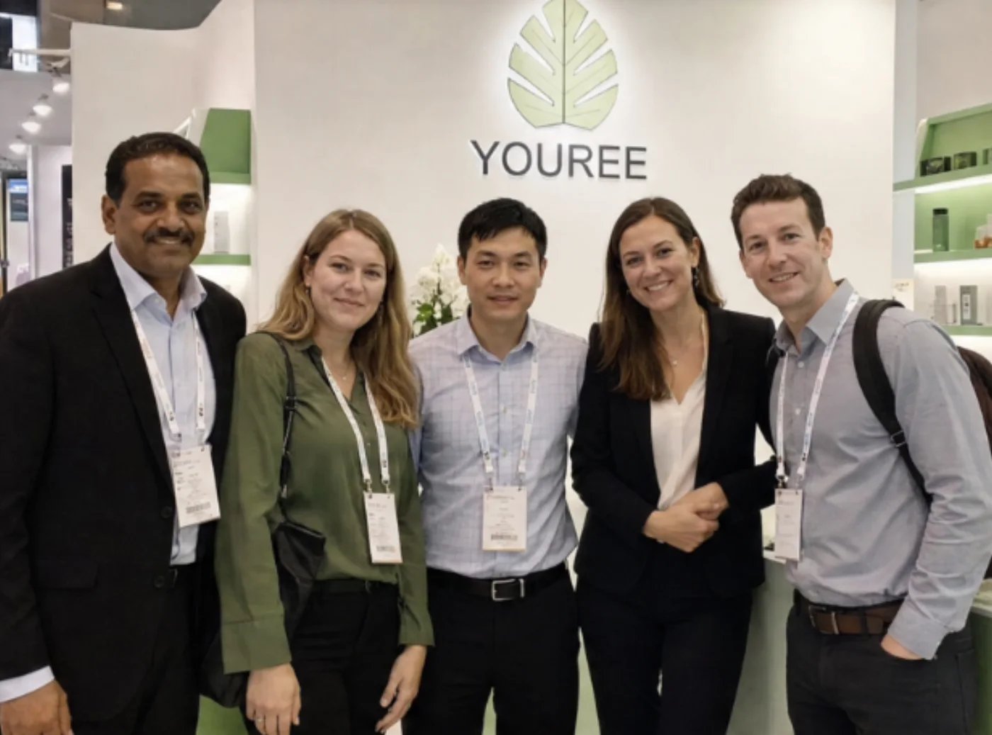 YOUREE team with international visitors at a beauty trade exhibition